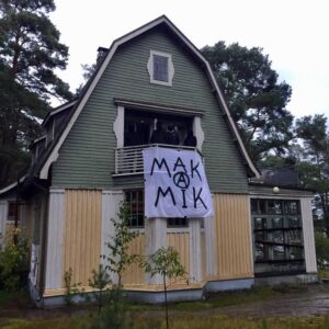 picture of squatted house, banner hanging from the window says MAK(A)MIK